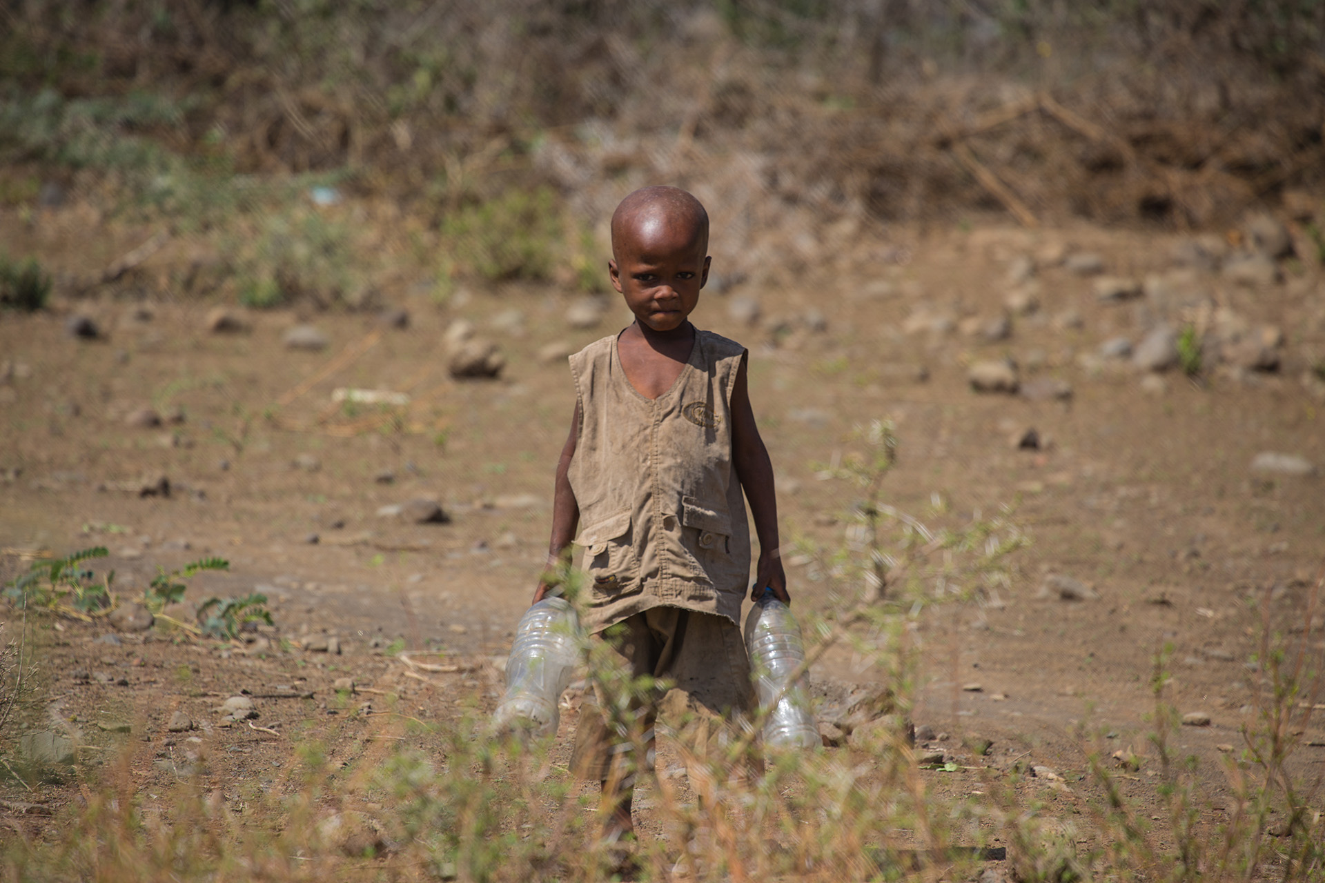 This very young boy couldn’t have been more than four years old. He had been sent by his parents to collect water from the bottom of the village. Like many Maasai, they were extremely adverse to have their photograph taken; they do not like it! His expression shows this rather too well.