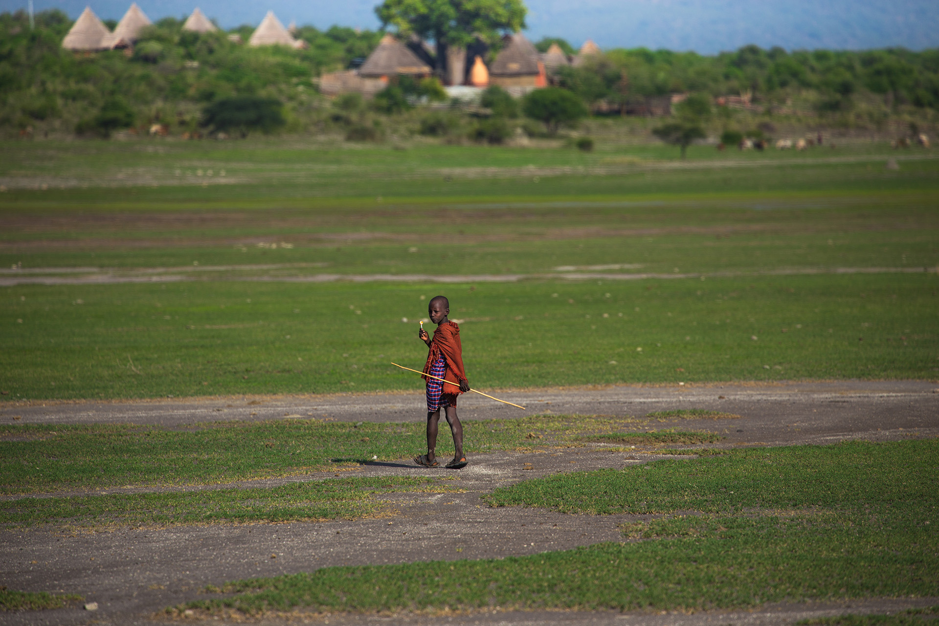 It is said that once they take these responsibilities, they must be mindful of the perils of them. Wearing red and carrying sticks certainly help to ease the mind – as the Maasai believe it discourages lions. In the huge expanse of this open land, a dried-up lake basin, these children must feel vunerable.