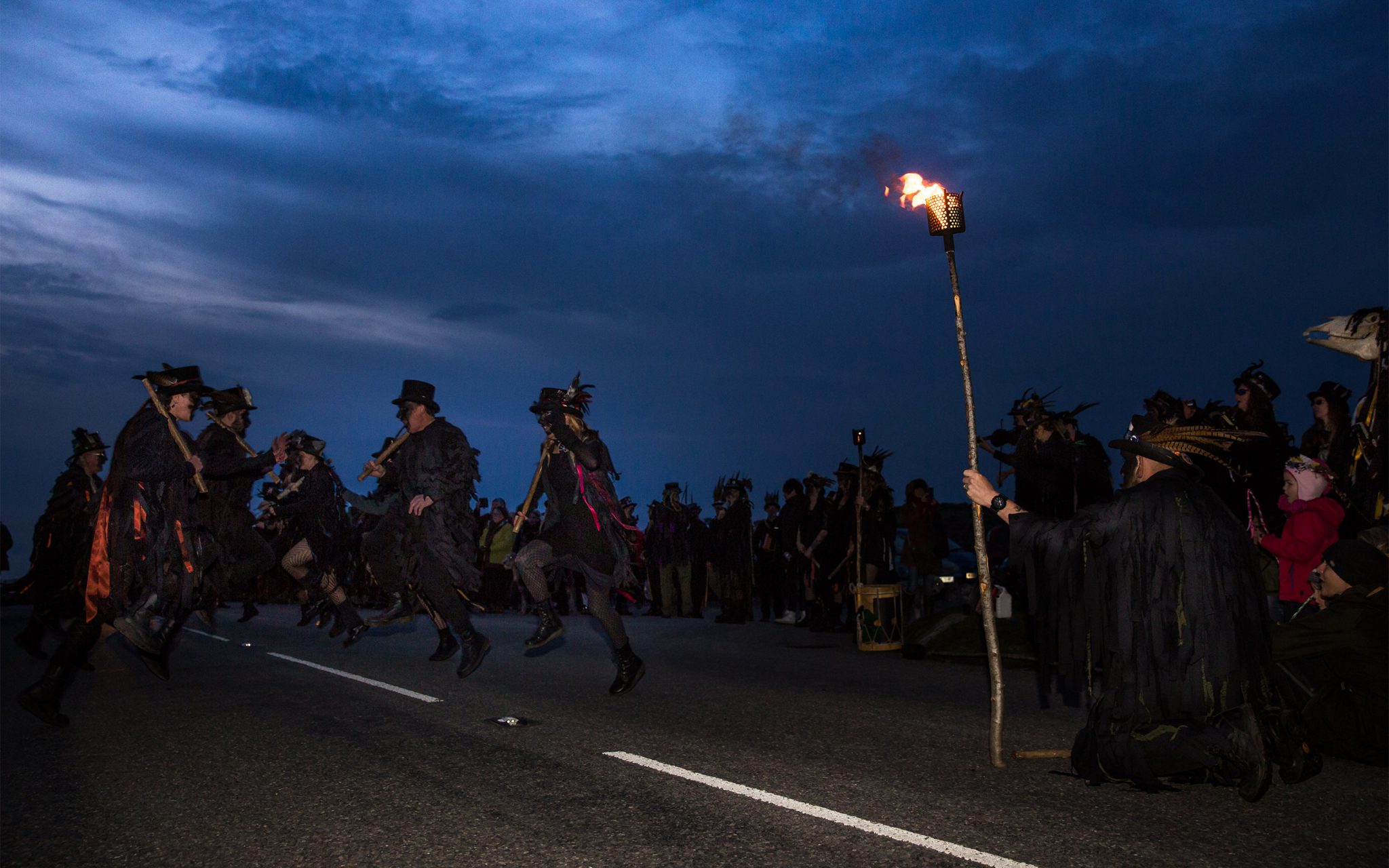 Photo journalism. Morris Dancing at dawn, HayTor on Dartmoor. Based upon ancient Pagan Festival celebrating the coming of summer on May 1st. Early-risers join the revelry with four separate Morris troops at HayTor, on top of Dartmoor. This photograph is ‘Beltane Border Morris Dancers’.The blackened faces is a tradition of the Border Morris folk, as a form of disguise to escape persecution of the law.
