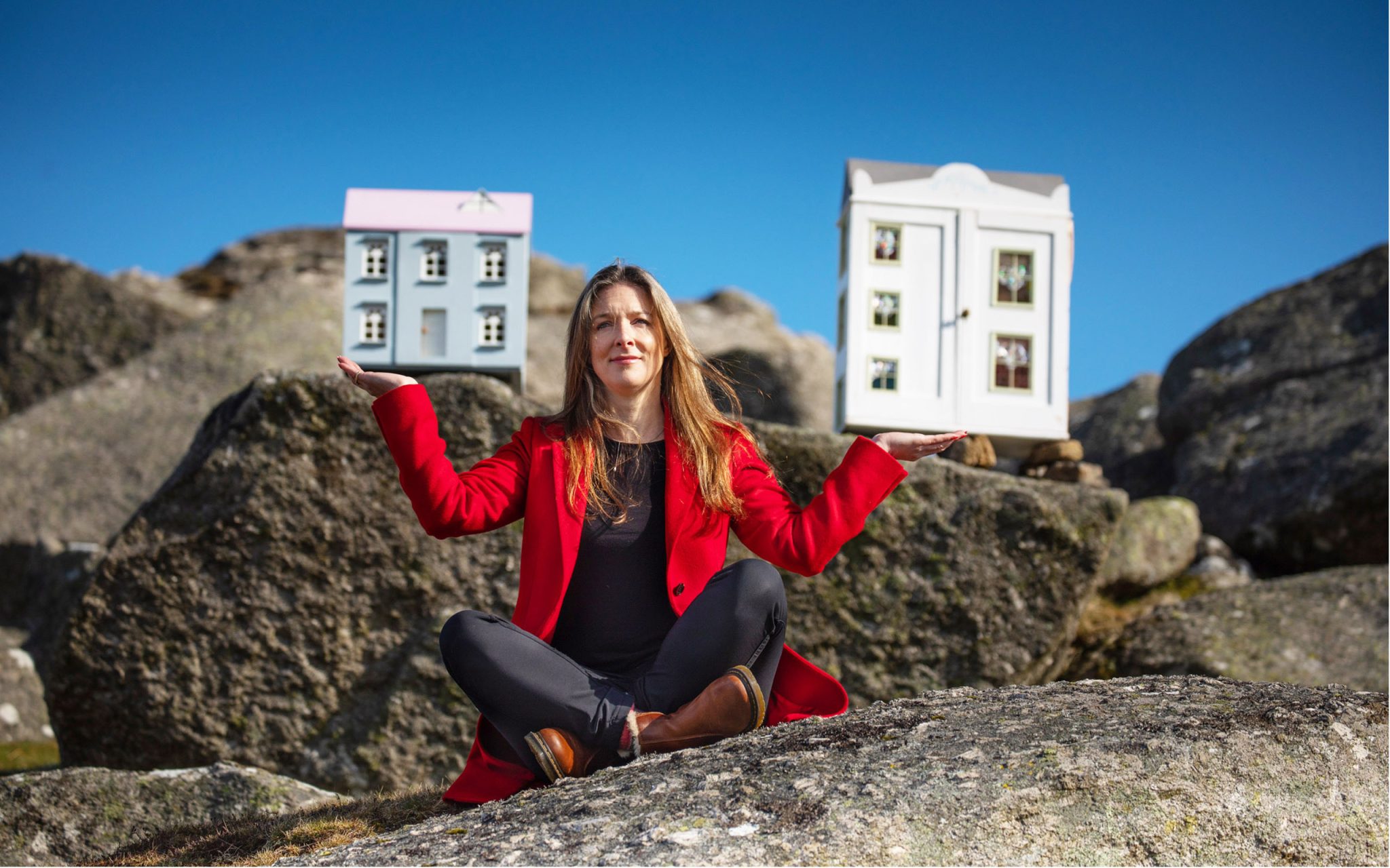 Kate Griffin of Sawdye & Harris Estate Agents holds aloft two fine houses, while practicing yoga at Bone Hill Rocks. #We Are Dartmoor. Part of the story commissioned by DNPA celebrating the people who make their livelihoods within the boundaries of Dartmoor National Park.